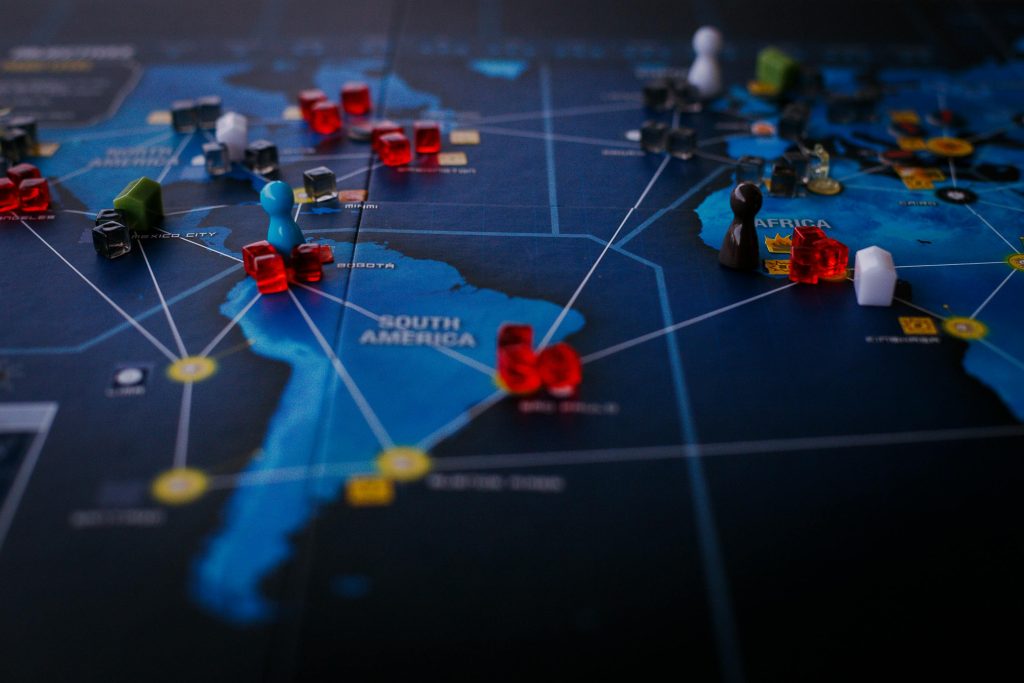 pexels photo 8159115 8159115 A strategic board game featuring a world map and colorful playing pieces.